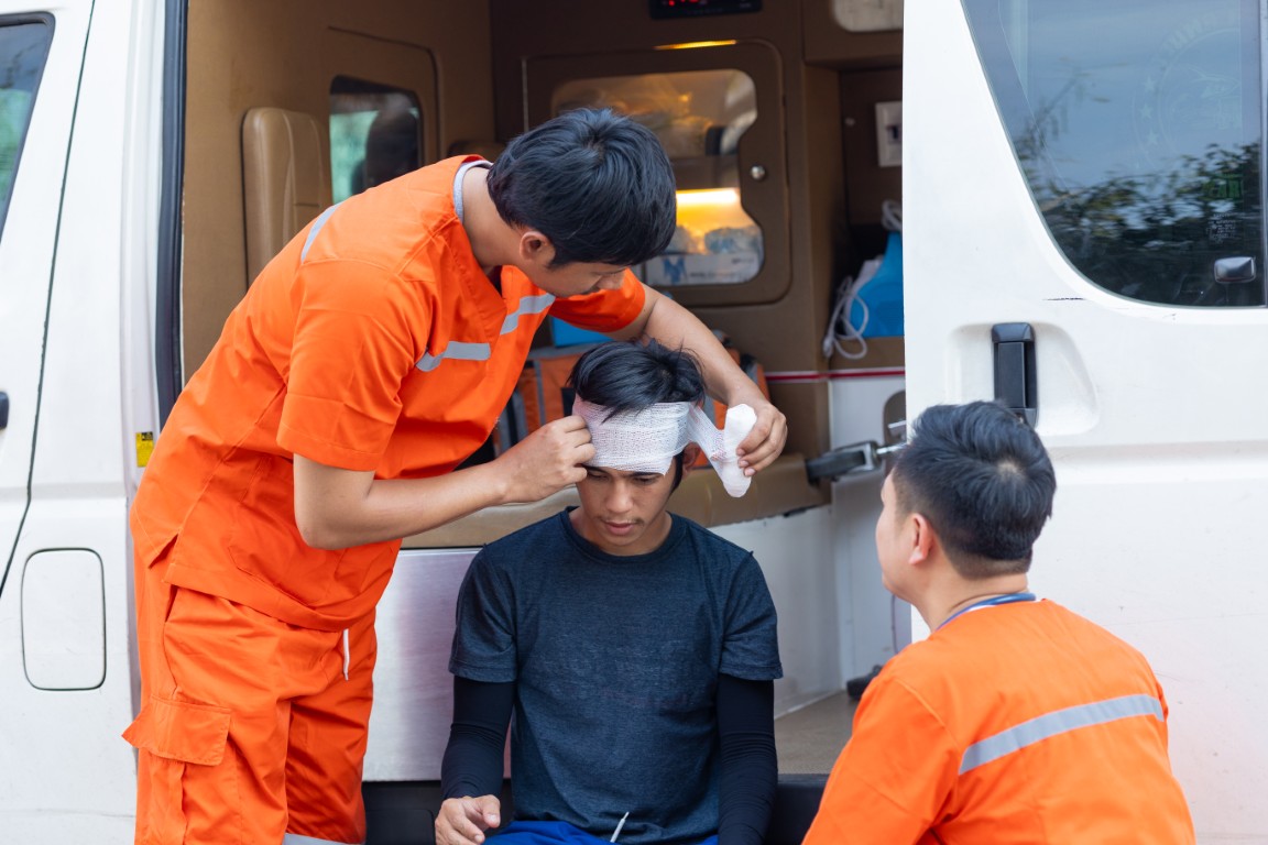 A man being treated for a head injury by emergency medical providers