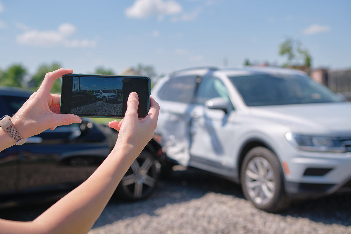 A female driver photographing a car accident scene