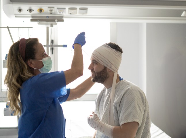A man with a head injury being treated by a healthcare provider