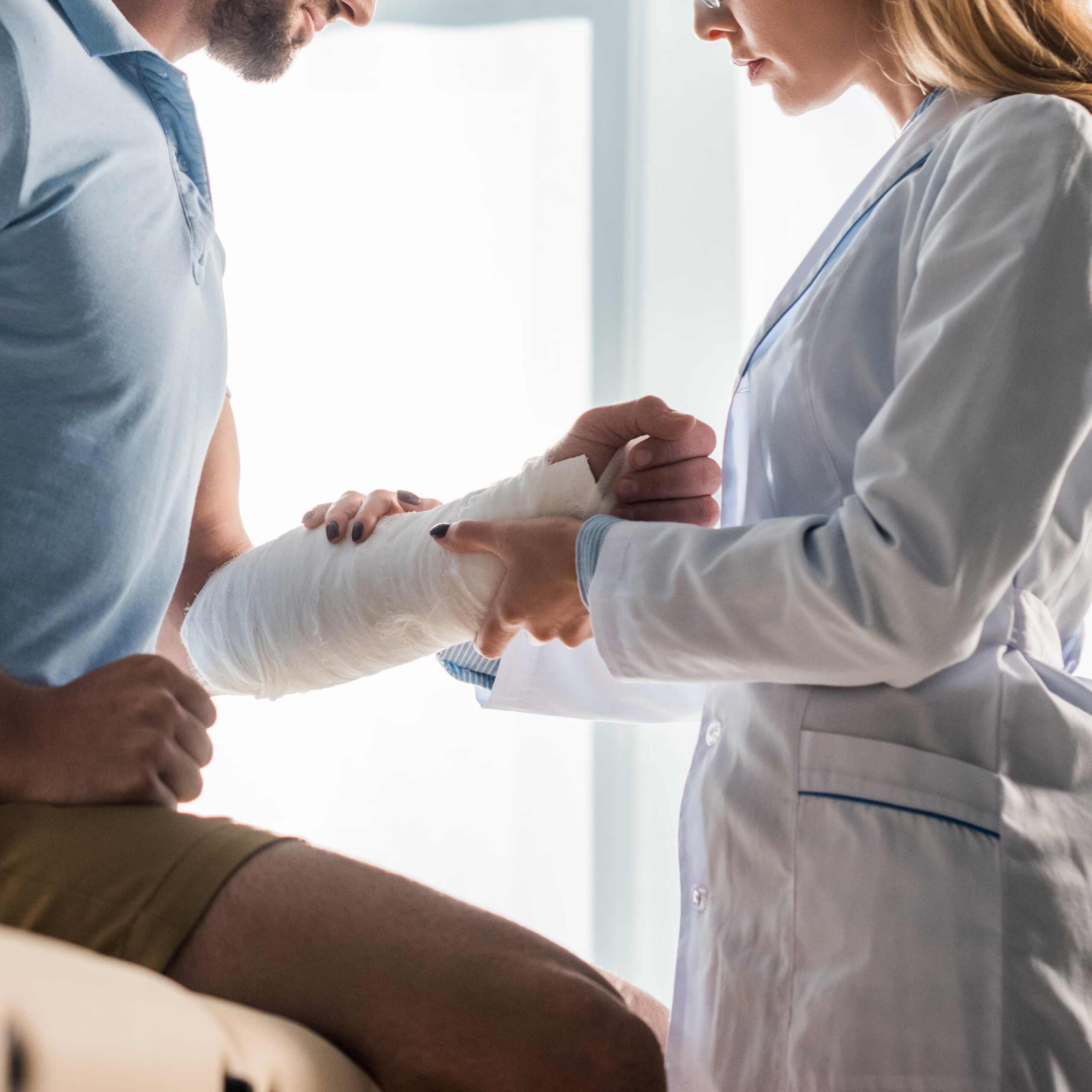 A doctor providing medical care to a patient with arm injuries